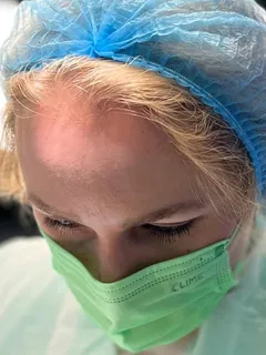 Dr. Ramona Drilea, cu bonetă și mască, în timpul unei intervenții.